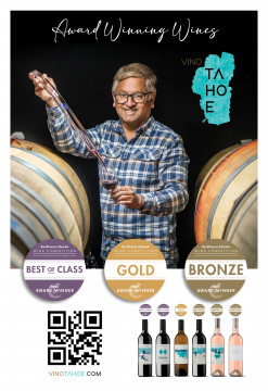 Winemaker with wine thief next to barrels