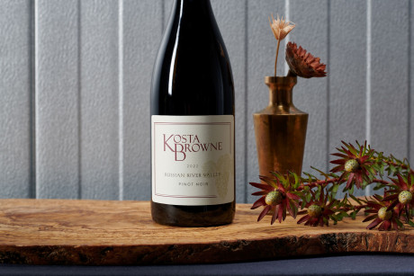 Kosta Browne Pinot Noir bottle on a wood table with wood carving decor