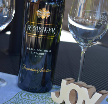 bottle of Rombauer Zinfandel and Joy sign