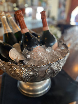 silver wine bucket with champagne bottles on ice