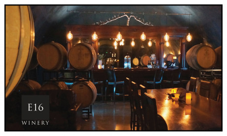 Inside barrel room with bar area at back of room and some seating