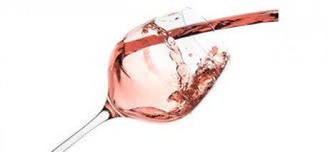 wine glass with pink wine pouring into it