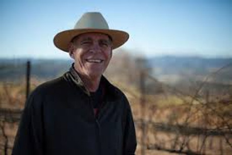 Owner Paul Schmitz in tan hat next to vineyards