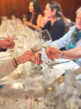 Toasting wine glasses at a restaurant dining table with a white tablecloth